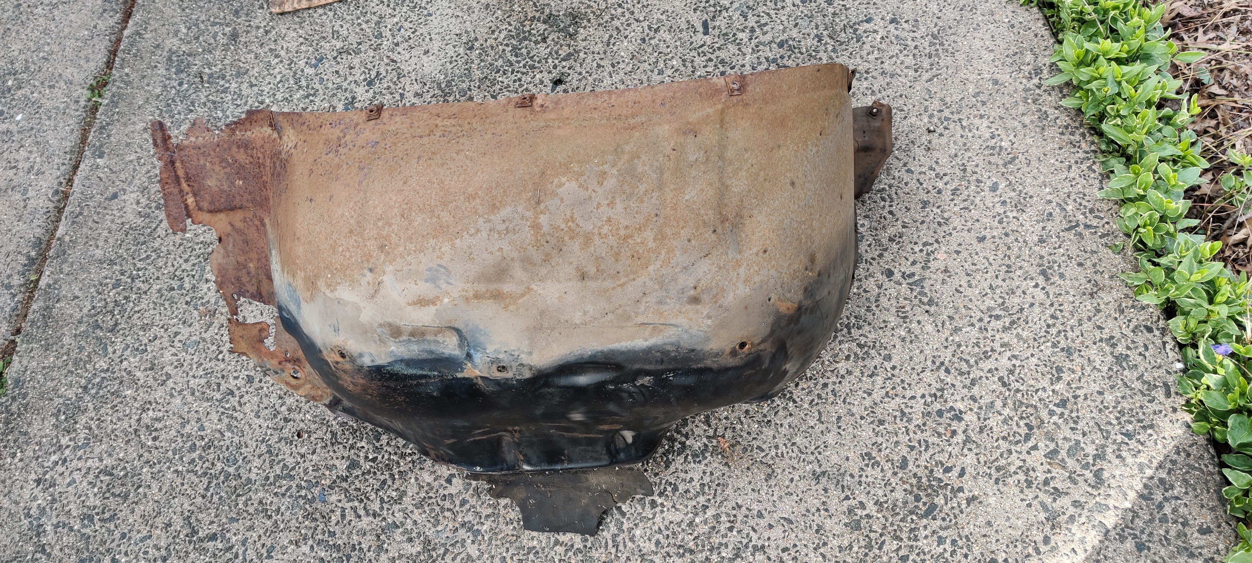 Old rusted out front right wheel well